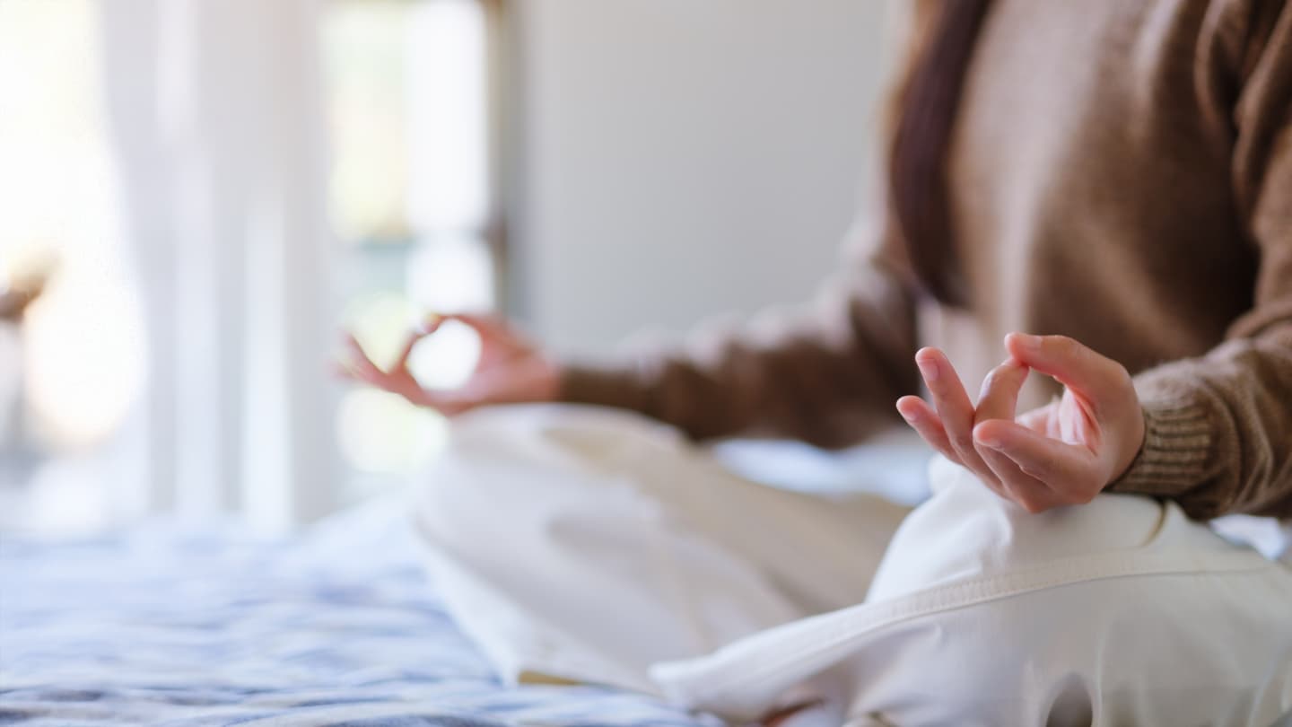 Morning Meditation in Gyan Mudra Person sitting on bed meditating with hands in gyan mudra