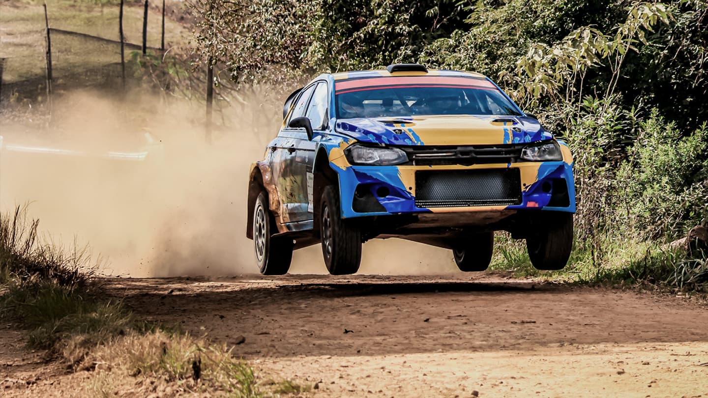 Rally Car Mid-Air Dirt Road Jump Blue and yellow rally car airborne on dusty dirt road
