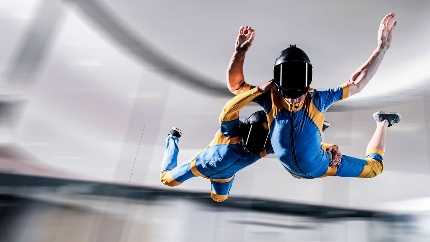 Indoor Skydiving Wind Tunnel Flight Indoor skydiver in blue and yellow suit flying in a wind tunnel