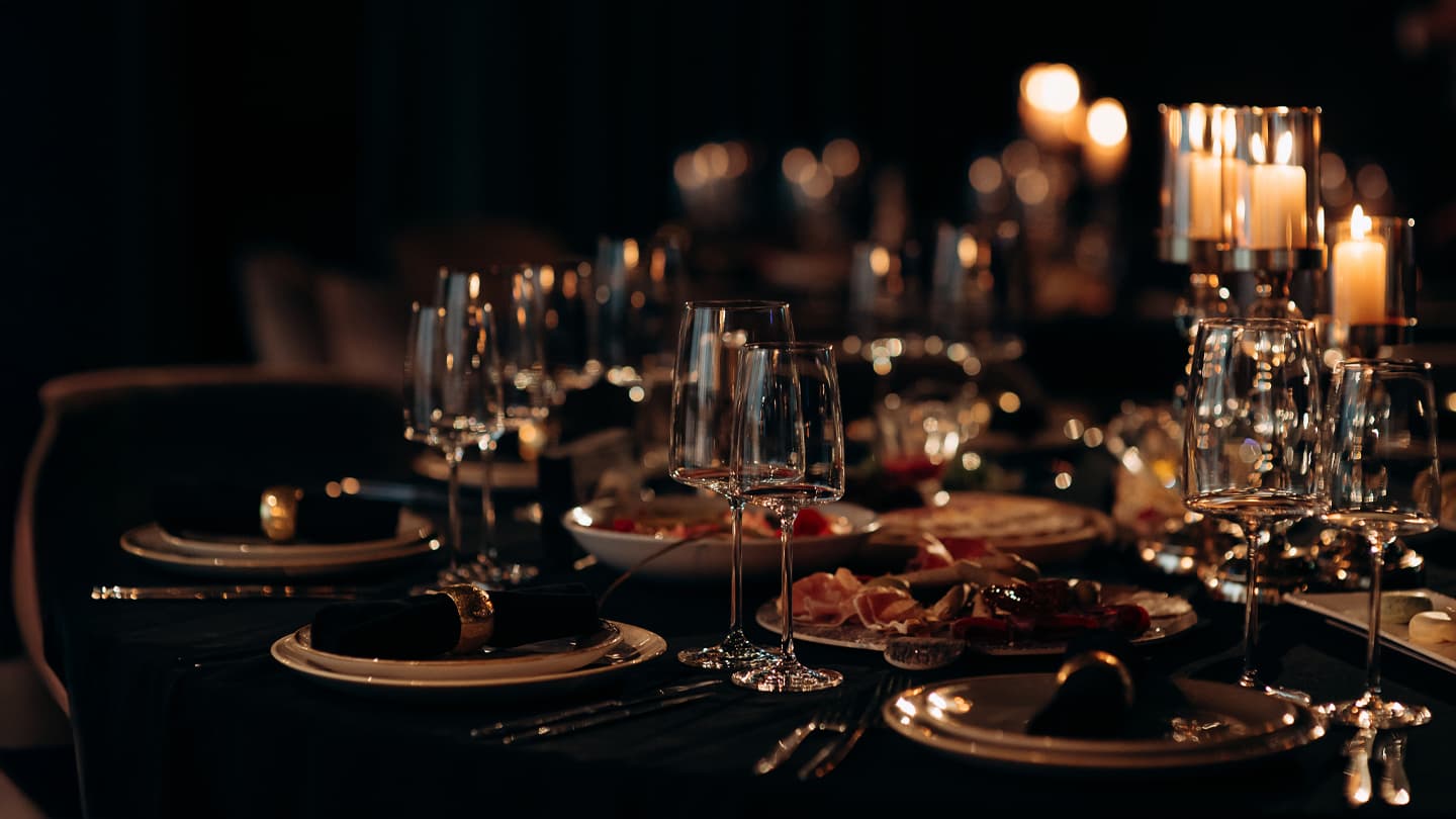 Candlelit Fine Dining Table Setting Elegant candlelit dinner table with crystal glasses and charcuterie