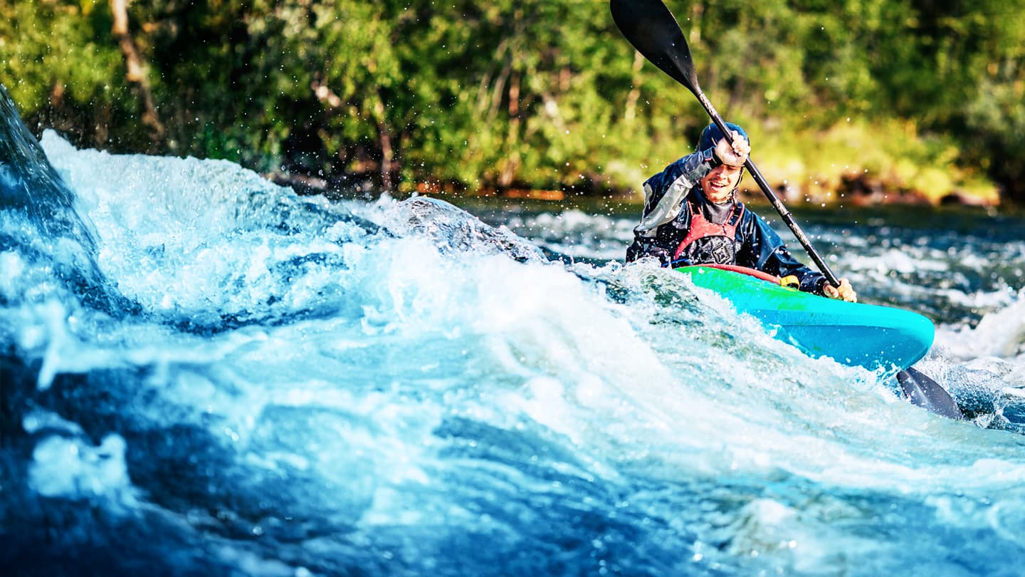 Whitewater Kayaking Adventure Kayaker navigating through whitewater rapids in a turquoise kayak with splashing water and green forest background