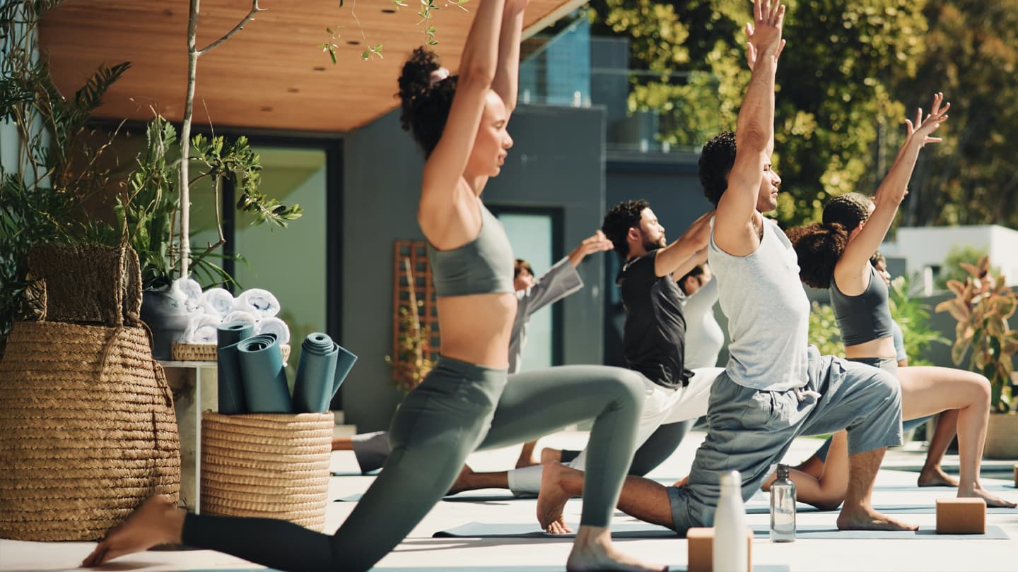 Outdoor Group Yoga Class Group of people practicing warrior pose in outdoor yoga class