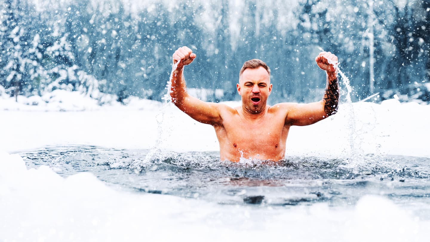 Winter Ice Plunge Celebration Shirtless man raising fists in triumph during a winter ice bath