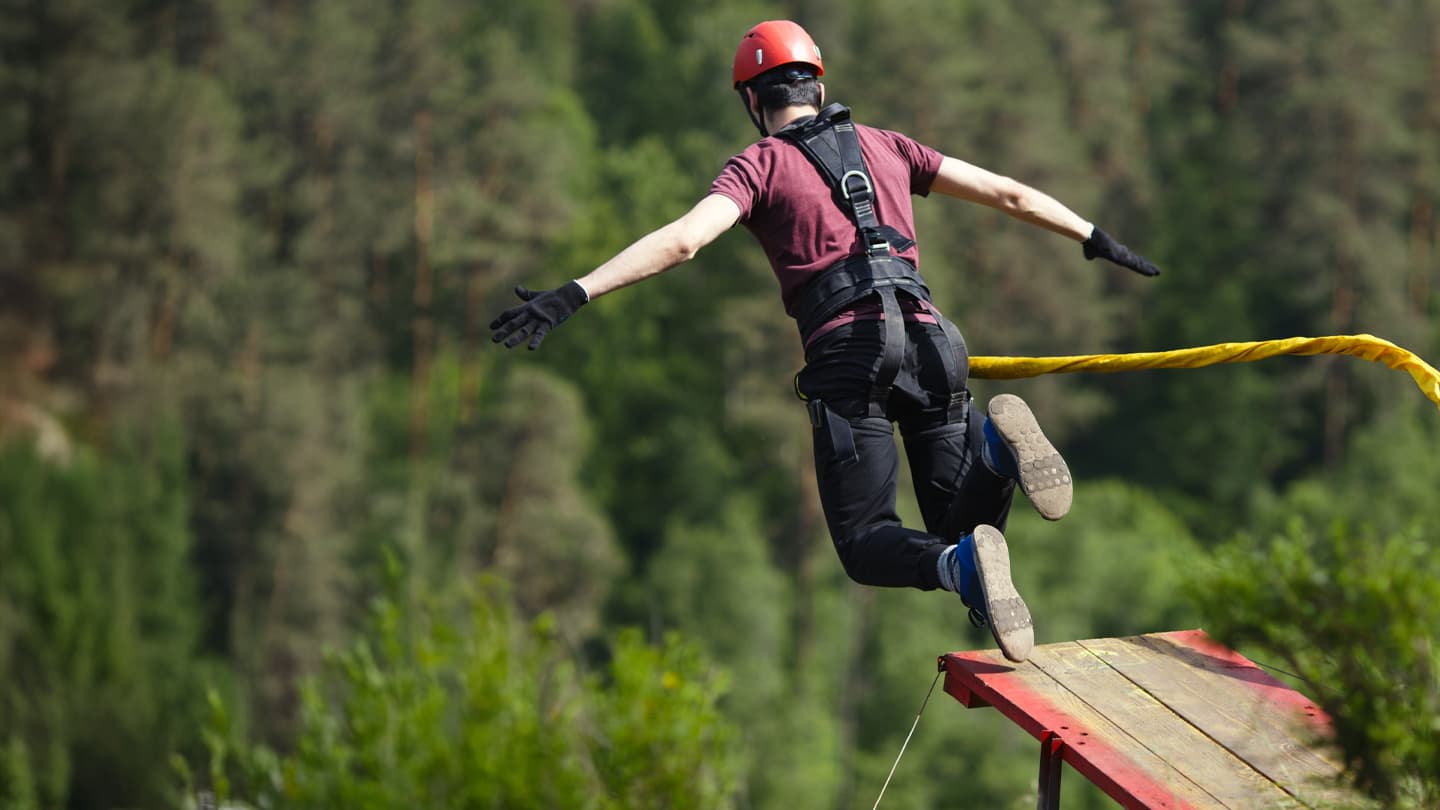 Bungee Jump Platform Leap Person in safety harness and helmet leaping from a bungee jump platform