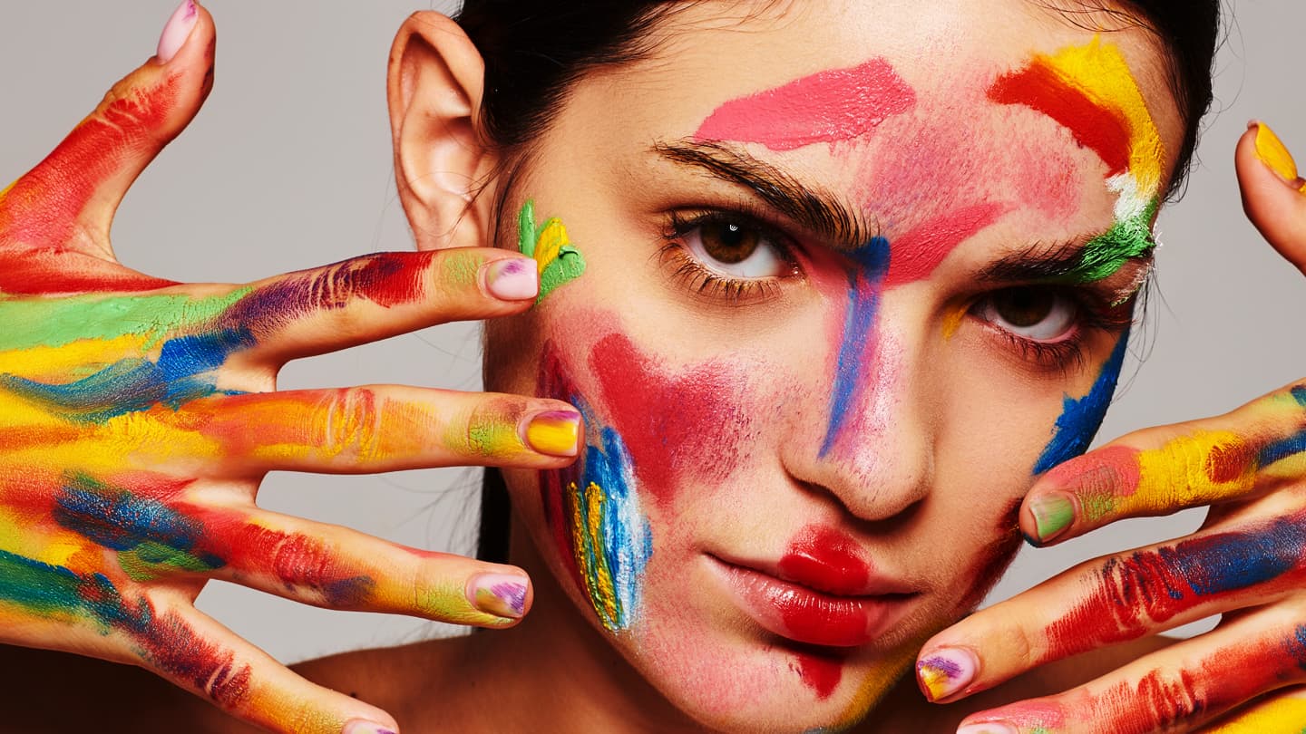 Colorful Paint Art Portrait Woman with colorful paint covering her face and hands