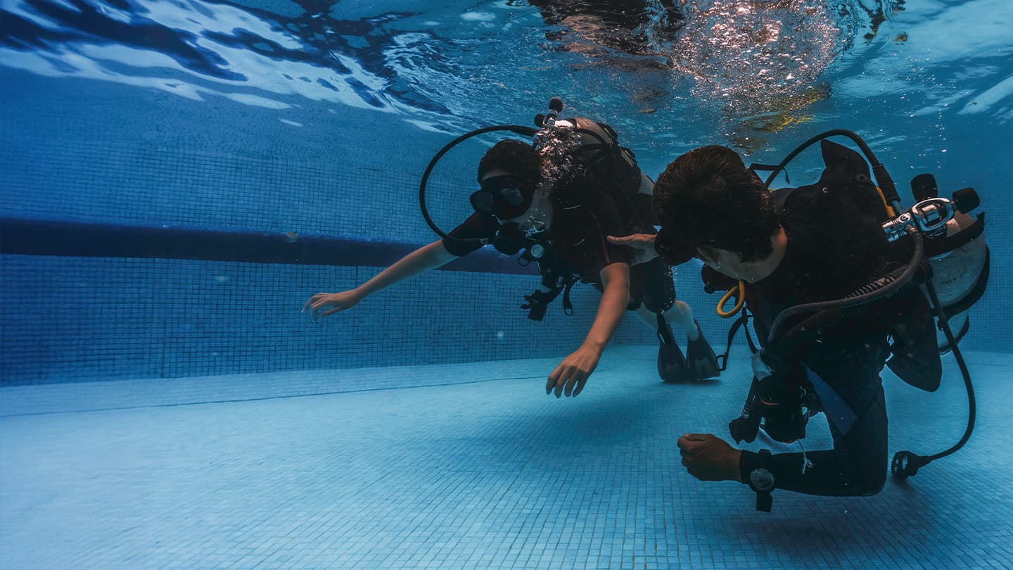 Scuba Diving Pool Training Session Two scuba divers practicing skills underwater in a training pool
