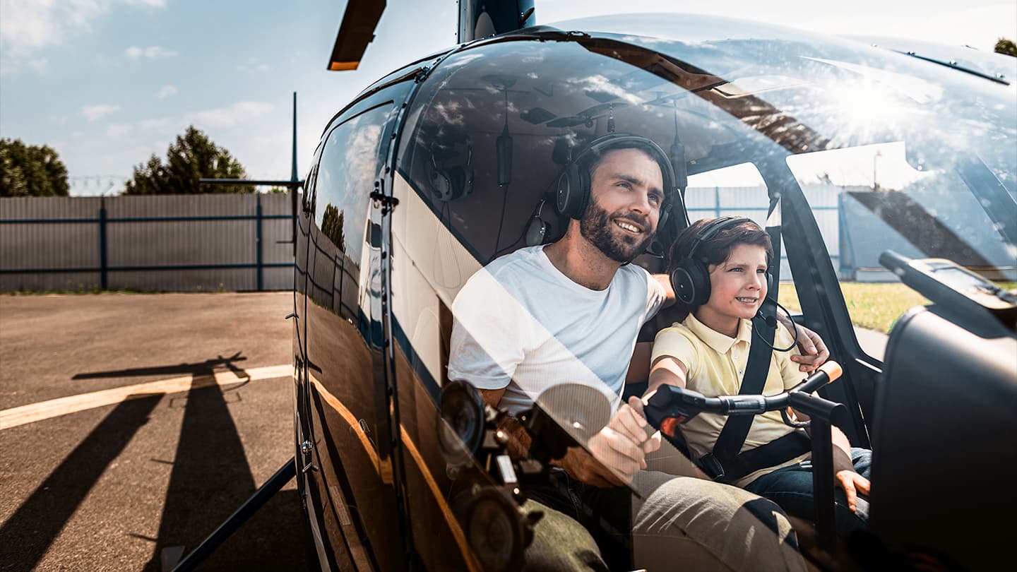 Father and Son Helicopter Cockpit Experience Father and young son sitting together in a helicopter cockpit wearing headsets