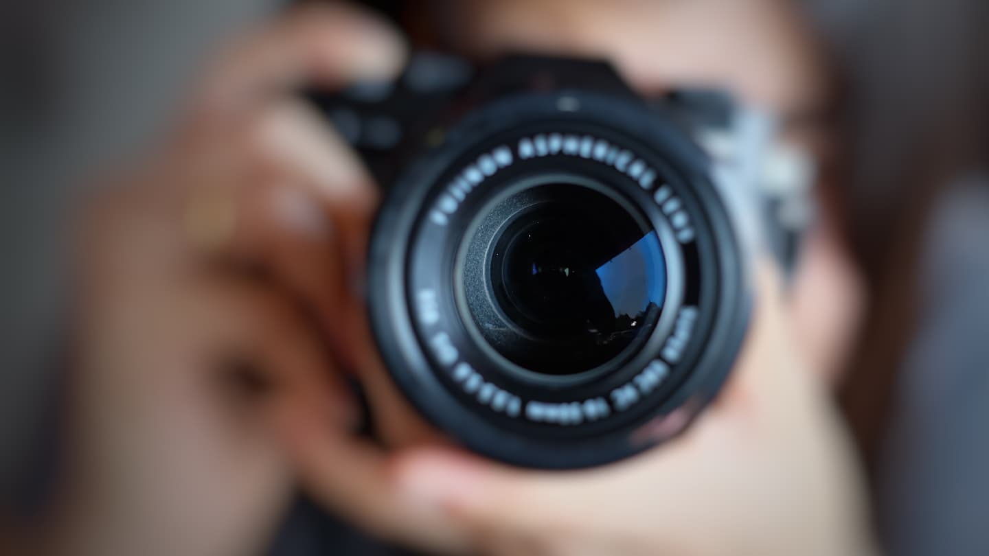 Camera Lens Close-Up View Close-up of a camera lens held by a photographer pointing forward