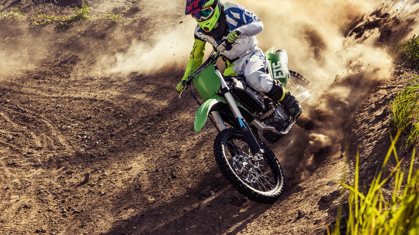Motocross Rider Cornering Through Dust Motocross rider leaning into a dusty dirt track corner.
