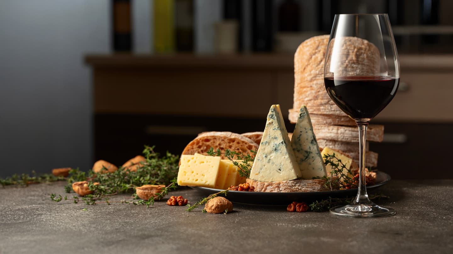 Red Wine and Cheese Pairing Glass of red wine with blue cheese, walnuts, and rustic bread