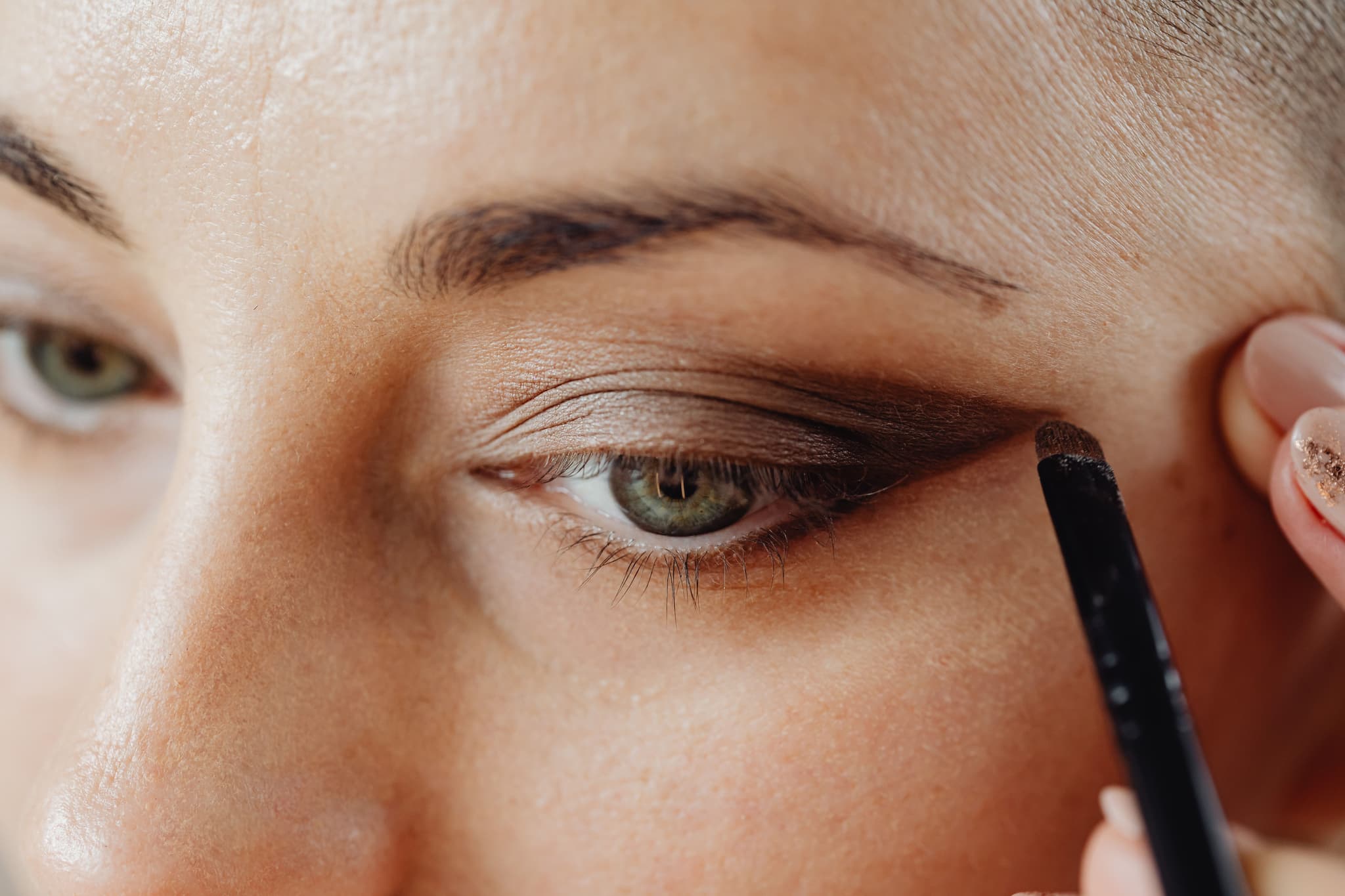 Eyeshadow Application with Makeup Brush Close-up of a person applying brown eyeshadow with a makeup brush.
