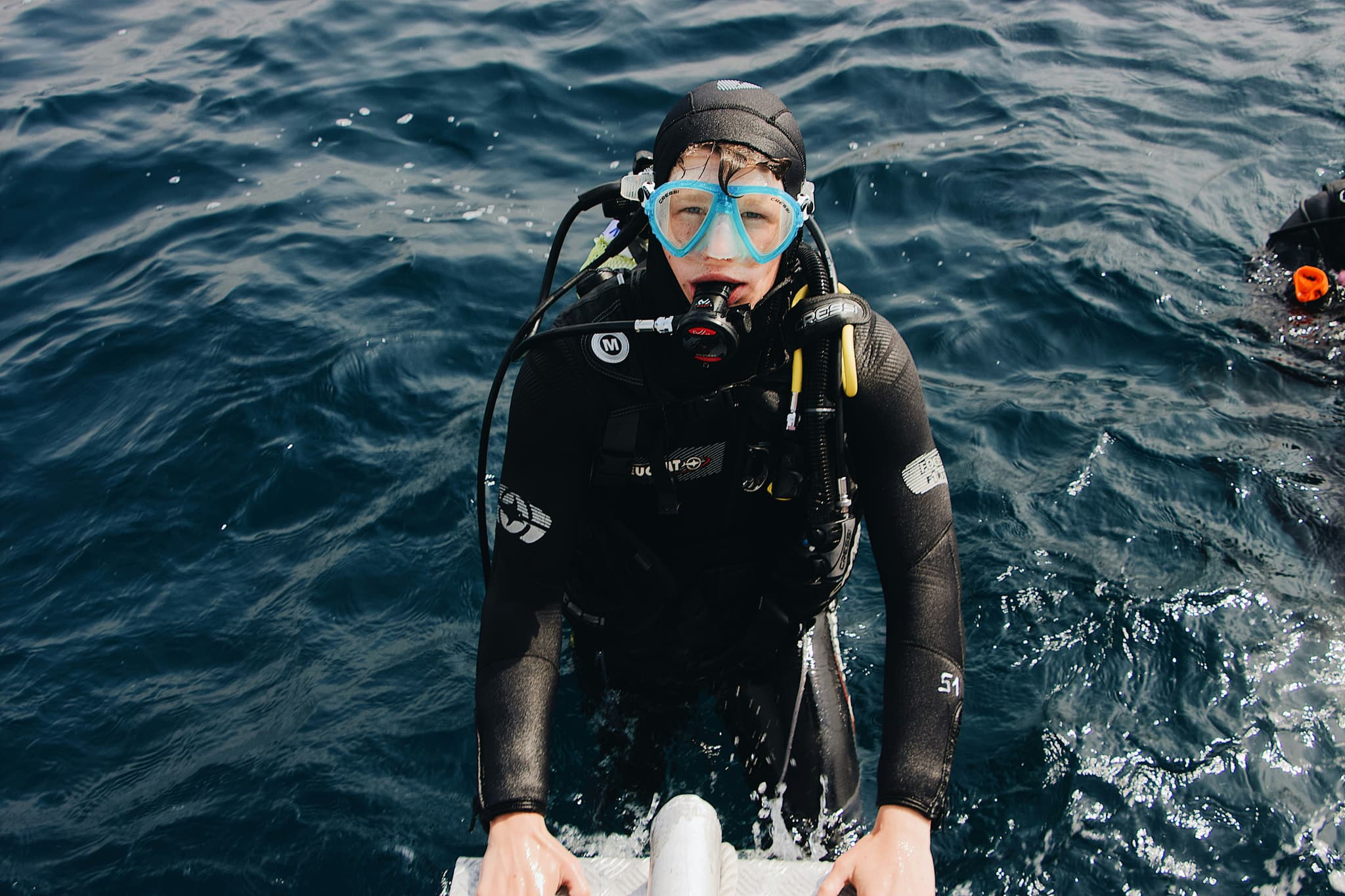 Scuba Diver in Open Ocean Scuba diver in blue mask and black wetsuit in open ocean water.