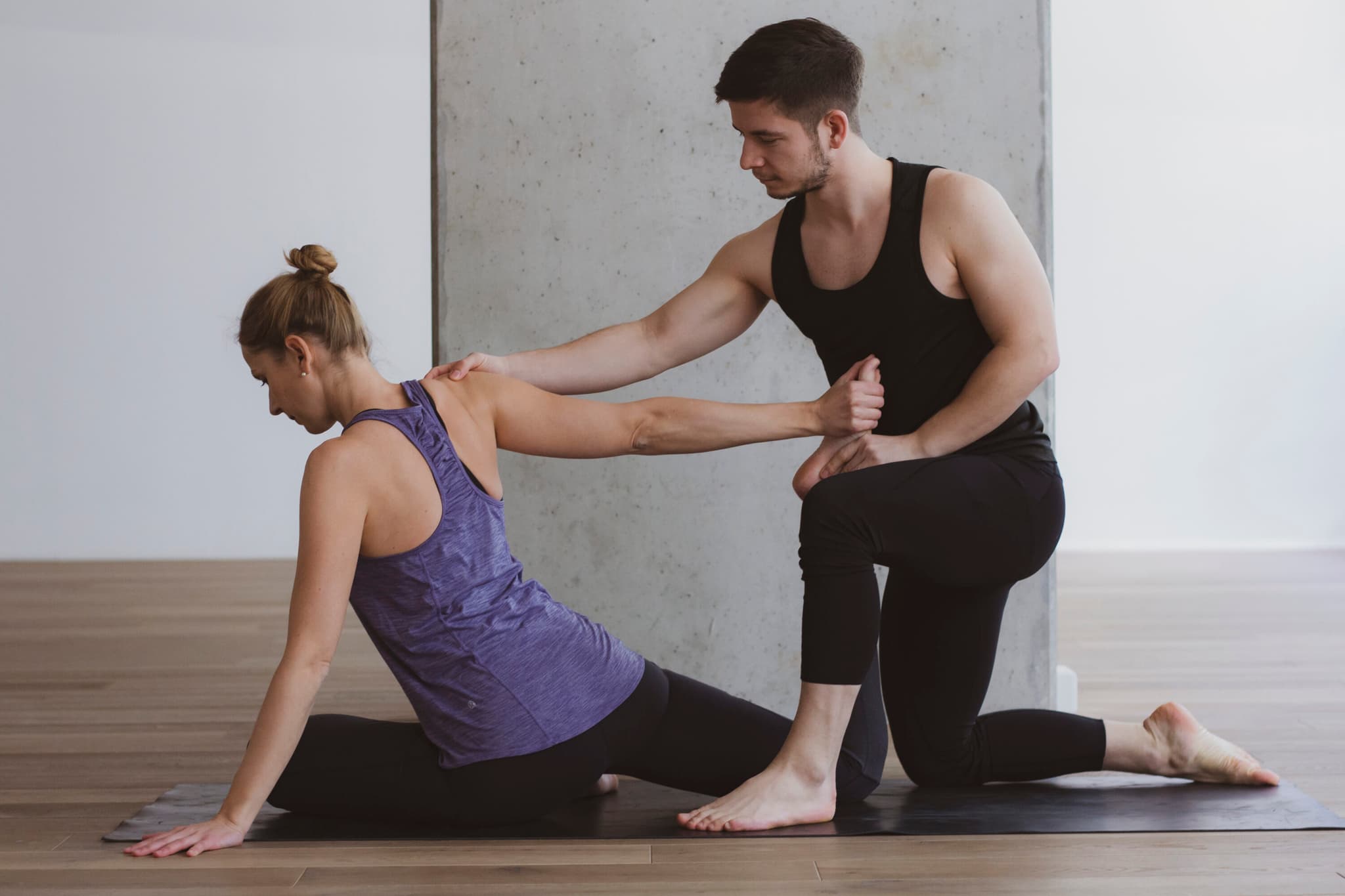 Trainer supports client through lunge exercise Fitness trainer guides a client through a lunge exercise in a bright indoor gym studio.