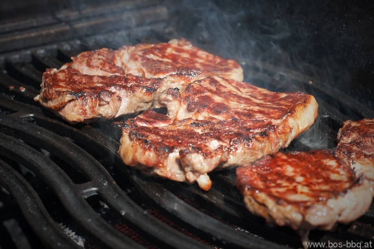 Grilled Steaks on the Grill Grate Grilled steaks with a browned crust on black grill grates.