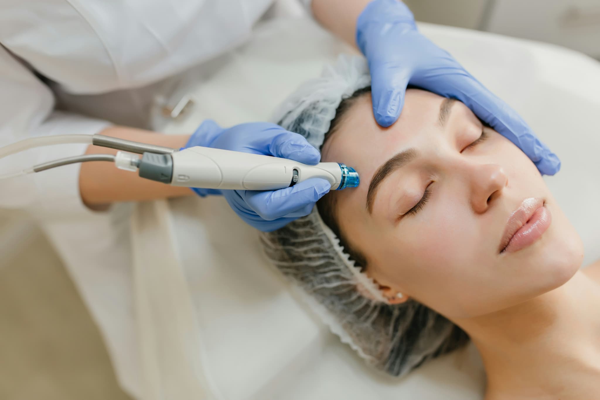 Facial Microdermabrasion Skincare Treatment Esthetician using a microdermabrasion device on a client's face.