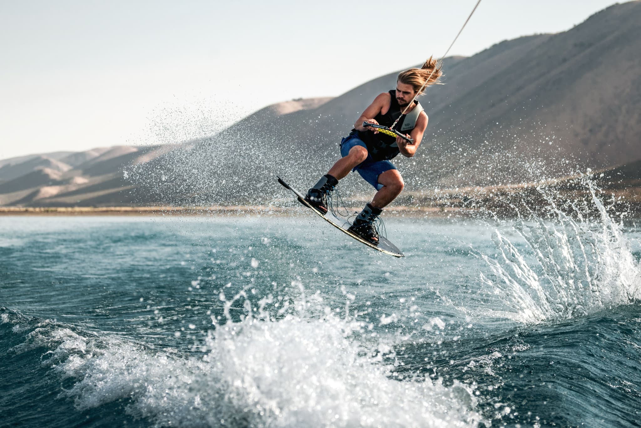 Wakeboarding on Mountain Lake Person wakeboarding on a lake with mountains in the background.