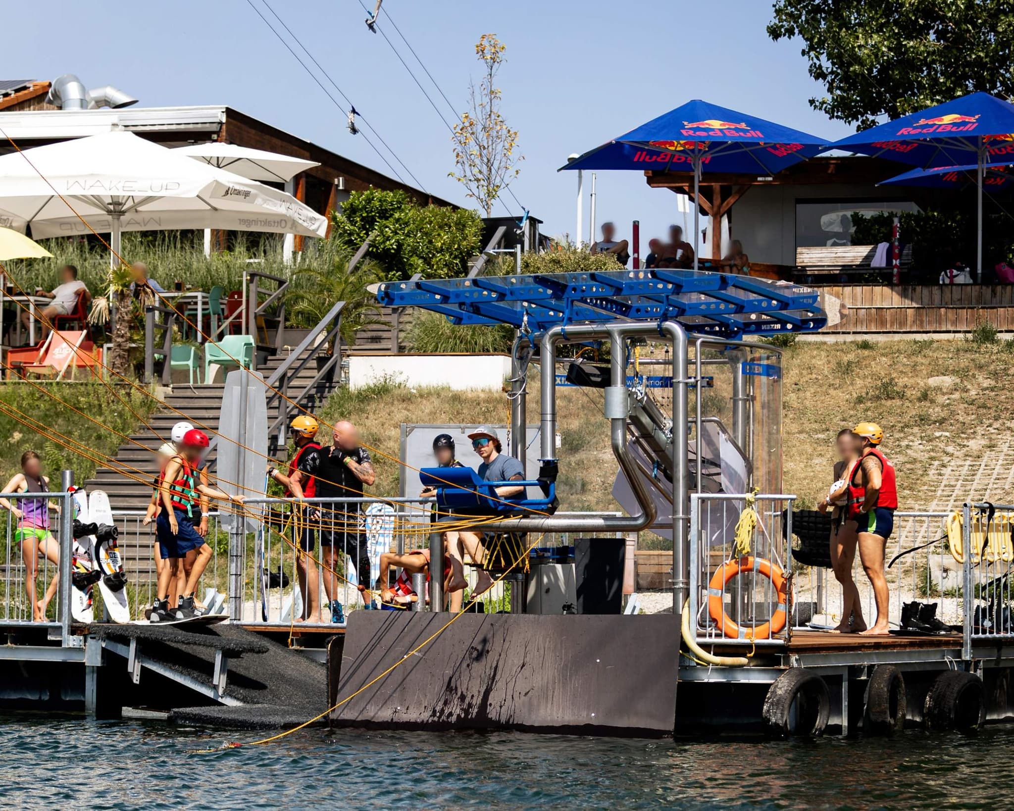 Zip-Line Adventure at the Water Sports Center Platform Zip-line adventure course at a water sports center with participants in safety gear preparing for the course