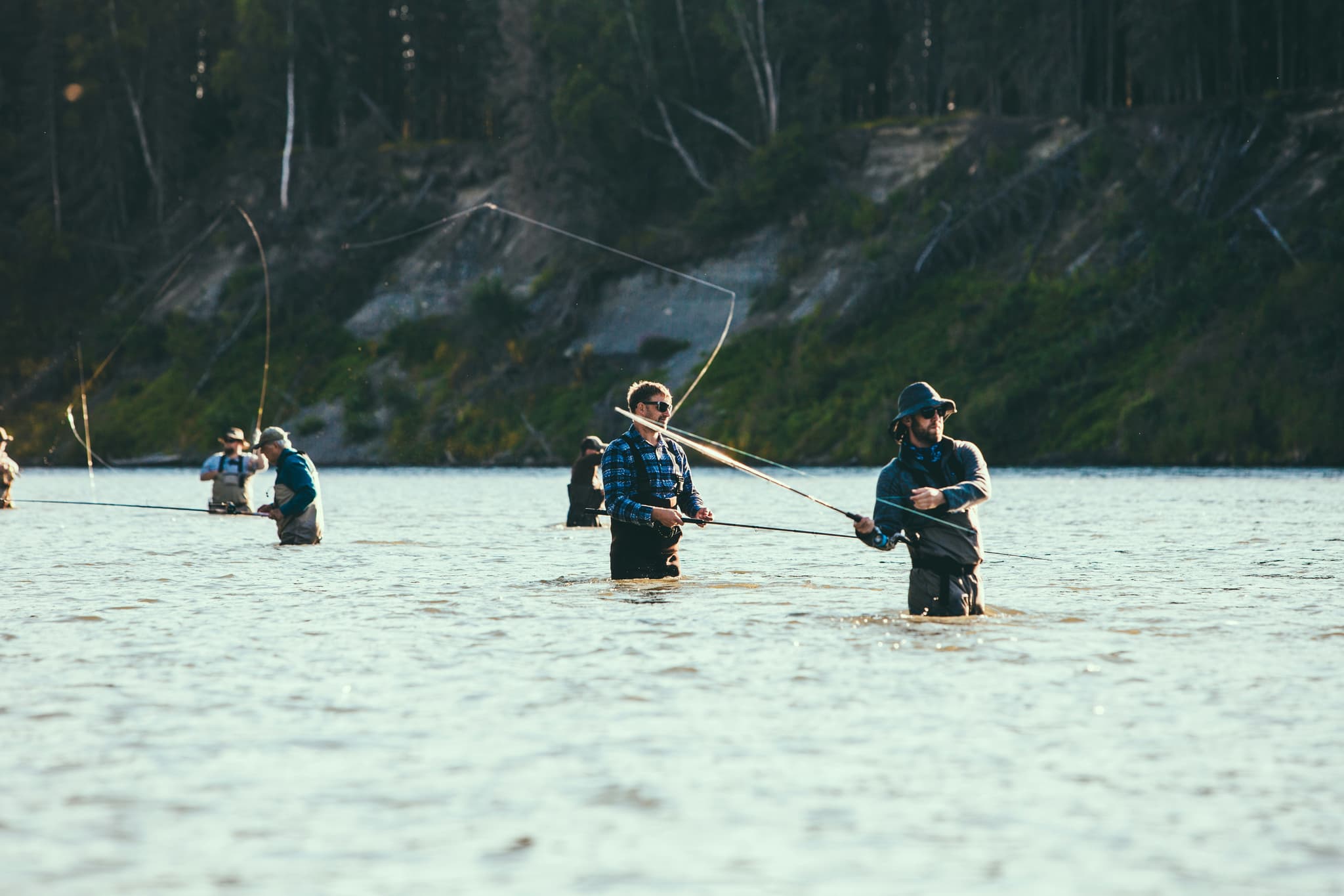 Fly Fishing on Mountain Lake Group of fly fishers wading in a mountain lake with forested hills in the background.