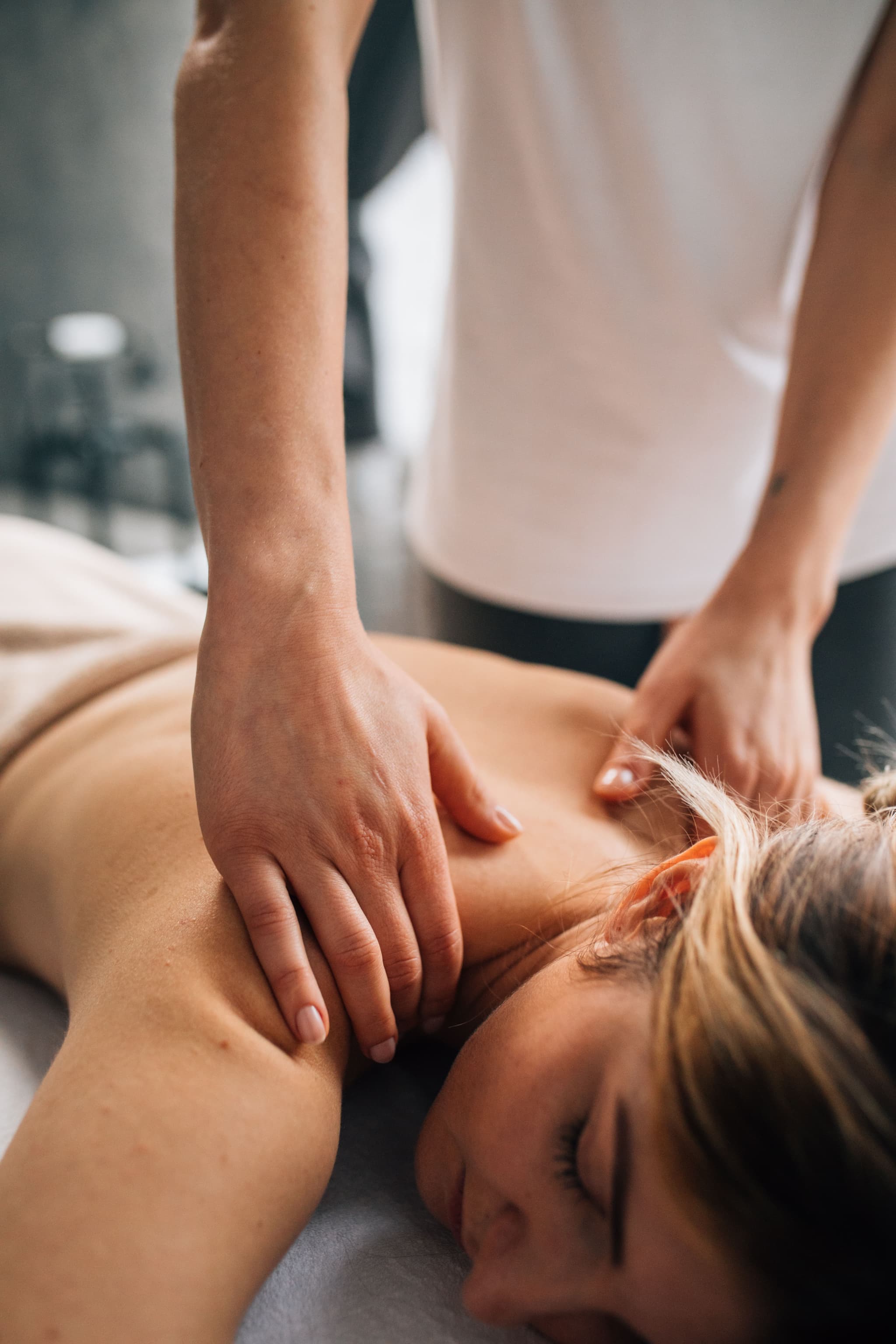 Massage Therapy on Back and Shoulder Therapist's hands pressing on a relaxed client's upper back during a massage.