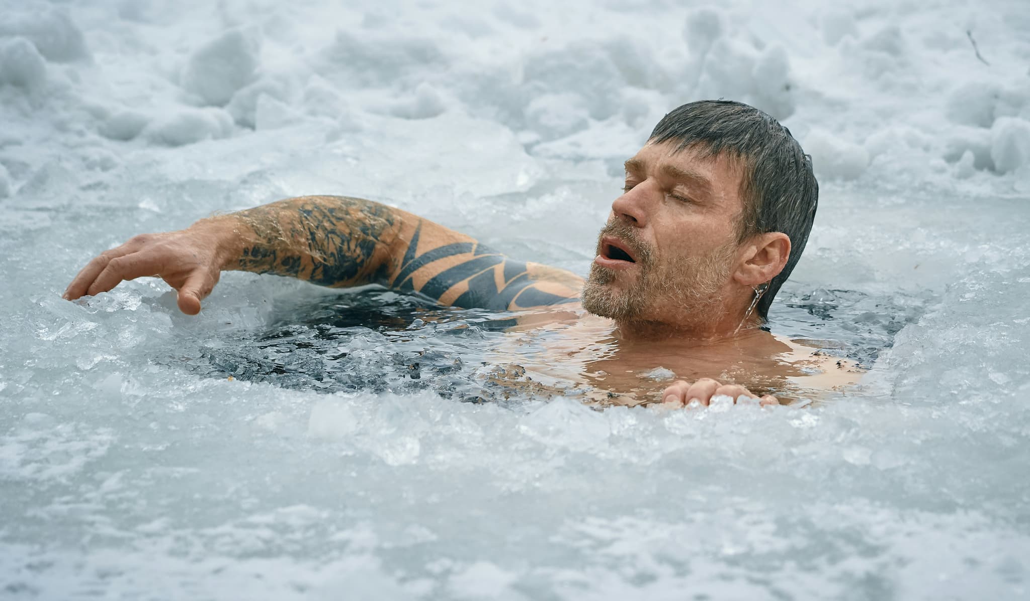 Ice Swimming in Winter Water Man swimming in ice-cold water with snow and ice formations in the background.