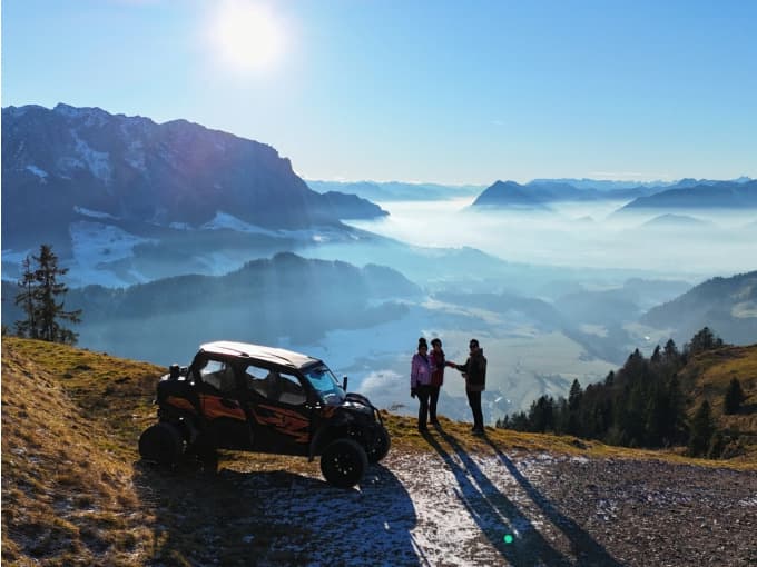 Off-Road Vehicle at Misty Mountain Viewpoint Off-road vehicle on a mountain ridge overlooking a fog-covered valley.